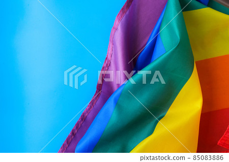 Rainbow flag on blue background with copy space. Rainbow lgbtq flag made from silk material. Symbol of LGBTQ pride month. Equal rights. Peace and freedom 85083886