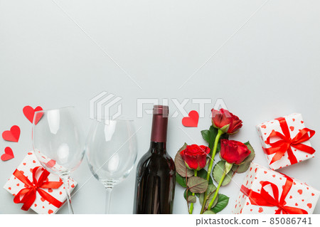 Valentine's day composition with red wine, rose flower and gift box on table. Top view, flat lay. Holiday concept Valentine's day composition with red wine, rose flower and gift box on table. Top view, flat lay. Holiday concept 85086741