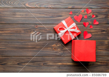Happy valentines day opened heart shape gift box with small hearts, on colored background, valentines day card - top view concept 85086789