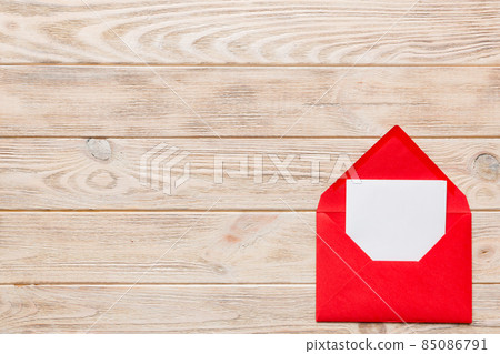 Red paper envelope with empty white card and heart on colored background. top view valentines day concept 85086791