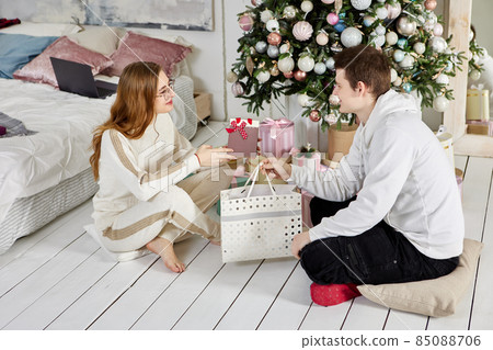 Giving Christmas gifts to young married couple. 85088706