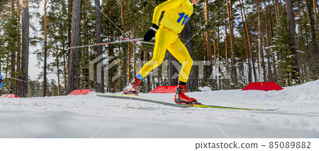 male skier in yellow skin suit running ski race 85089882