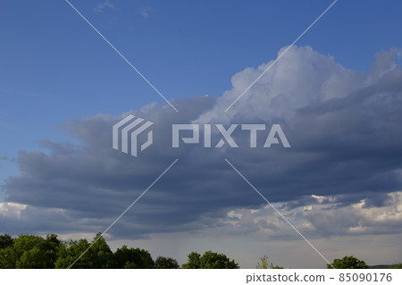 The sky in anticipation of rain and thunderstorms. Summer high sky and trees below. Blue sky with white clouds and treetops The sky in anticipation of rain and thunderstorms. Summer high sky and trees below. Blue sky with white clouds and treetops 85090176