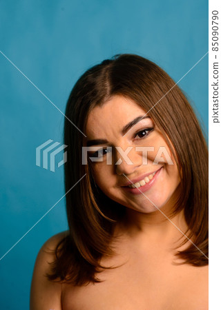 Beautiful emotional plus-size female model in pink and black bodysuit posing on background in studio 85090790