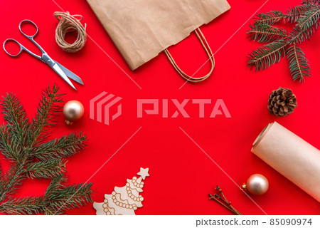 Christmas and new year festive Flat lay mock up gifts making, preparation and wrapping in kraft paper package on red background. 85090974