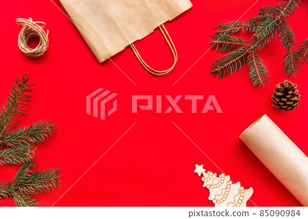 Christmas and new year festive Flat lay mock up gifts making, preparation and wrapping in kraft paper package on red background. Christmas and new year festive Flat lay mock up gifts making, preparation and wrapping in kraft paper package on red background. 85090984