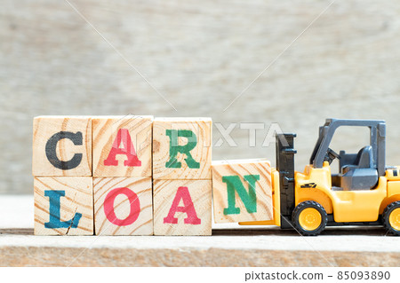 Toy forklift hold letter block n in word car loan on wood background Toy forklift hold letter block n in word car loan on wood background 85093890
