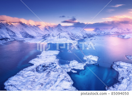 Aerial view of sea, snowy islands, mountains, road, violet sky 85094050