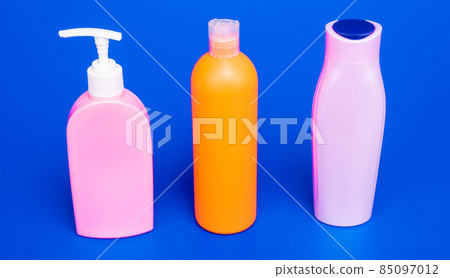 Easy to refill and dispense. Toiletry bottles in row. Refillable bottles blue background 85097012