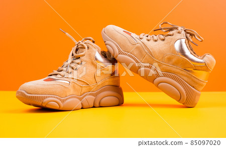 beige sport shoes on orange background, footwear beige sport shoes on orange background, footwear 85097020