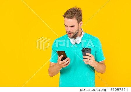 guy with coffe check sms on yellow background, communication guy with coffe check sms on yellow background, communication 85097254
