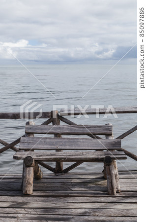 Old wooden bench stands at the pier 85097886