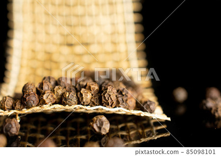 Spicy black pepper on black glass 85098101