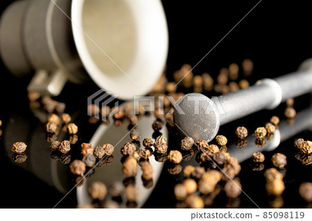 Spicy black pepper on black glass 85098119