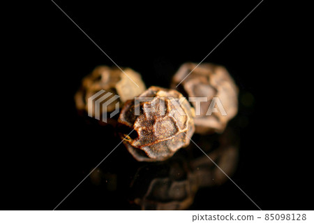 Spicy black pepper on black glass Spicy black pepper on black glass 85098128