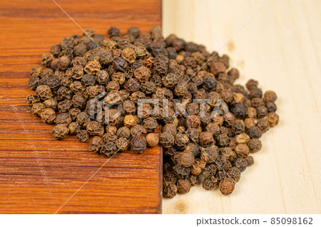 Spicy black pepper on plain wood Spicy black pepper on plain wood 85098162