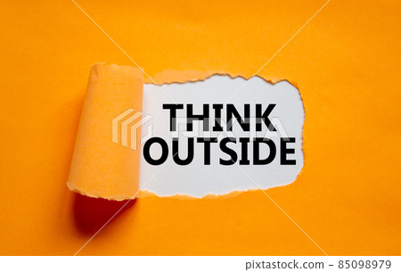 The text 'think outside' appearing behind torn orange paper. Business concept. Copy space. The text 'think outside' appearing behind torn orange paper. Business concept. Copy space. 85098979