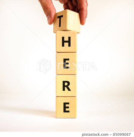 There or here symbol. Businessman turns a wooden cube, changes the word 'there' to 'here'. Beautiful white table, white background, copy space. Business, there or here concept. There or here symbol. Businessman turns a wooden cube, changes the word 'there' to 'here'. Beautiful white table, white background, copy space. Business, there or here concept. 85099087