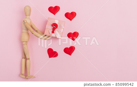 Valentines Day gift selection pink background, hearts wooden mannequin top view 85099542