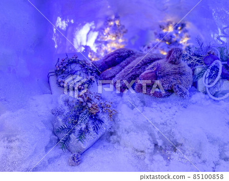 Festive design scene: a toy bear sleeps in a snow-covered den, a decorated tree behind him Festive design scene: a toy bear sleeps in a snow-covered den, a decorated tree behind him 85100858