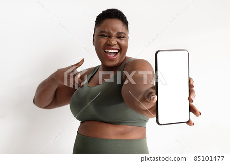 Smartphone with empty screen in overweight athletic black lady hand 85101477