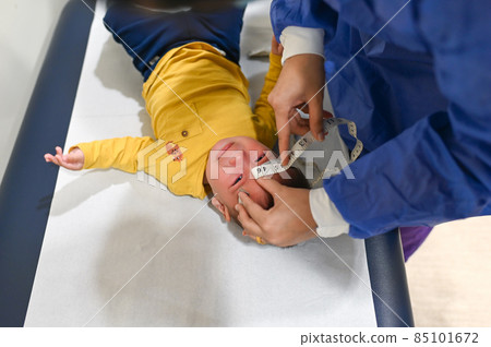 Pediatrician measuring baby boy at the doctors office for a routine checkup and physical exam to track progress at the hospital Pediatrician measuring baby boy at the doctors office for a routine checkup and physical exam to track progress at the hospital 85101672