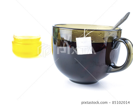 Cup of tea and honey on a white background with free space for text. Cup of tea and honey on a white background with free space for text. 85102014