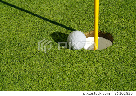 Close-up of Golf Course Green, Flag Pin and Ball. Close-up of Golf Course Green, Flag Pin and Ball. 85102836