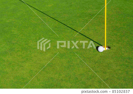Close-up of Golf Course Green, Flag Pin and Ball. Close-up of Golf Course Green, Flag Pin and Ball. 85102837