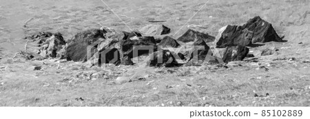 A natural grouping of rocks on the beach. 85102889
