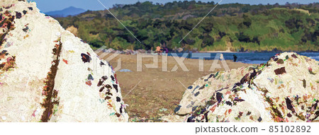 View on the beach through 2 rocks. 85102892