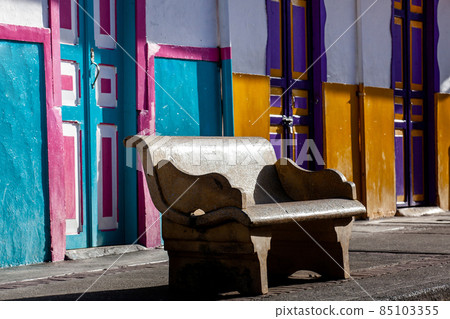 Empty bench at a beautiful street of the small town of Salento located at the region of Quindio in Colombia 85103355