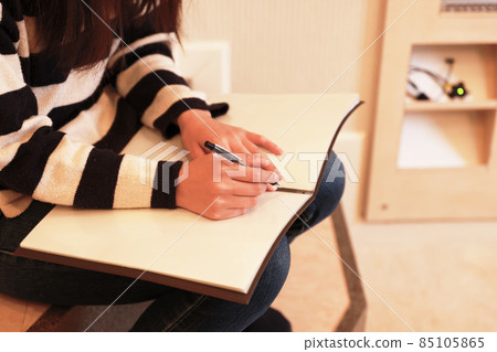 A woman writing a diary 85105865