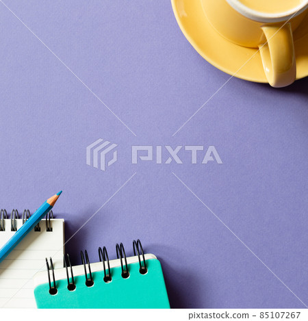 Notepad and mug cup on purple background. flat lay, top view, copy space Notepad and mug cup on purple background. flat lay, top view, copy space 85107267