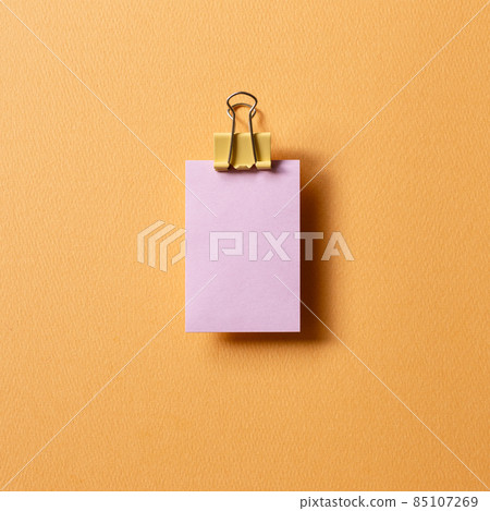 Blank purple sticky note pad and metal clip on orange background. top view, copy space Blank purple sticky note pad and metal clip on orange background. top view, copy space 85107269