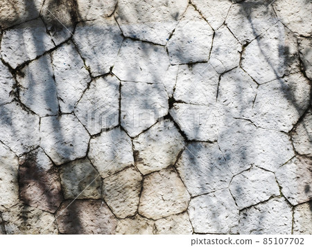 White rough granite tile wall with moldy seams illuminated by sunlight 85107702
