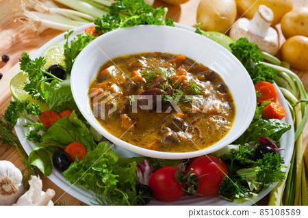 Delicious goulash from chicken hearts served with vegetables and lettuce Delicious goulash from chicken hearts served with vegetables and lettuce 85108589