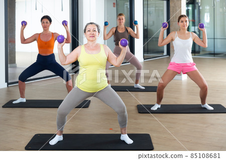 Women with dumbbells doing exercises 85108681