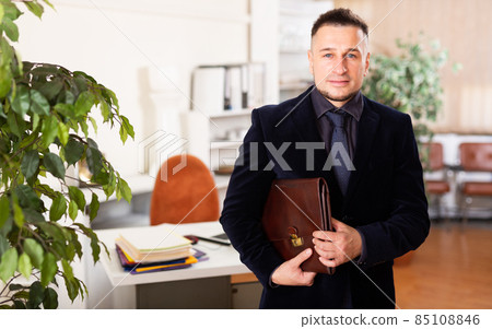 Confident young man working at office Confident young man working at office 85108846