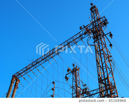 Railway electric iron poles with wires on blue sky background Railway electric iron poles with wires on blue sky background 85108968