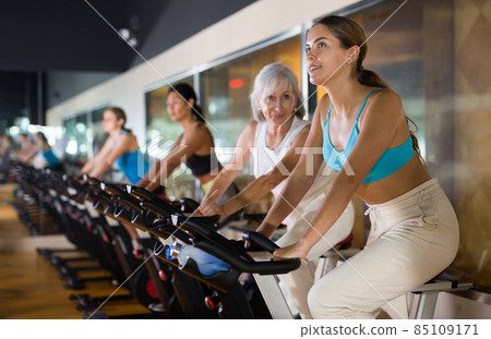 Young girl on training using bike in gym 85109171