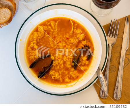 Seafood rice broth with wine and bread Seafood rice broth with wine and bread 85109382