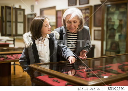 Senior woman and tween girl observing arts and crafts in museum Senior woman and tween girl observing arts and crafts in museum 85109391