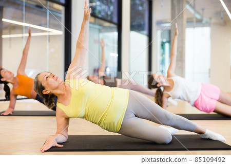 Group of women doing side plank Group of women doing side plank 85109492