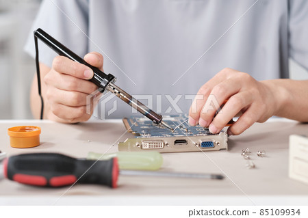 Hands of young contemporary technician with soldering iron 85109934