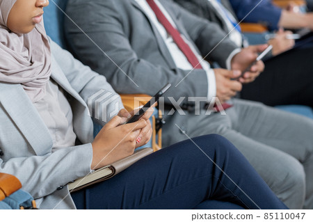 Young Muslim businesswoman scrolling in mobile phone 85110047