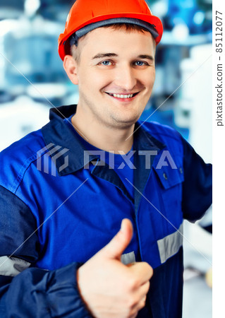 Young engineer in helmet shows thumbs up. Thumbs up. Great mood and good business. Positive worker Young engineer in helmet shows thumbs up. Thumbs up. Great mood and good business. Positive worker 85112077