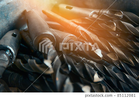Used drill bits on metal close-up. Set of steel drills in lathe workshop. Background. Used drill bits on metal close-up. Set of steel drills in lathe workshop. Background. 85112081