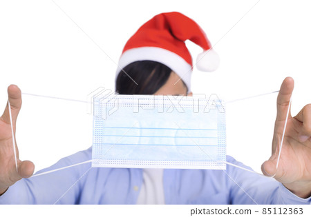 Young man Christmas hat showing face maskcovid-19 Young man Christmas hat showing face maskcovid-19 85112363