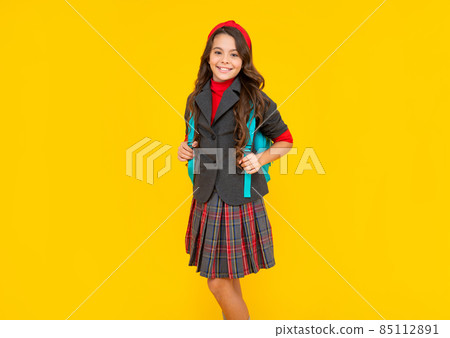 cheerful kid in school uniform and backpack on yellow background, childhood cheerful kid in school uniform and backpack on yellow background, childhood 85112891